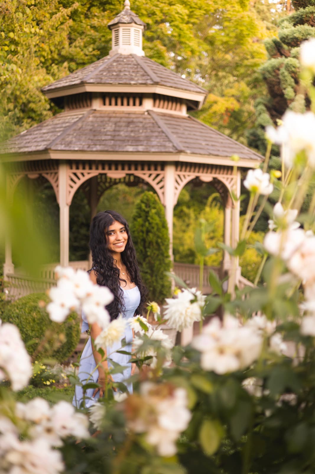 Senior portrait session by a garden gazebo