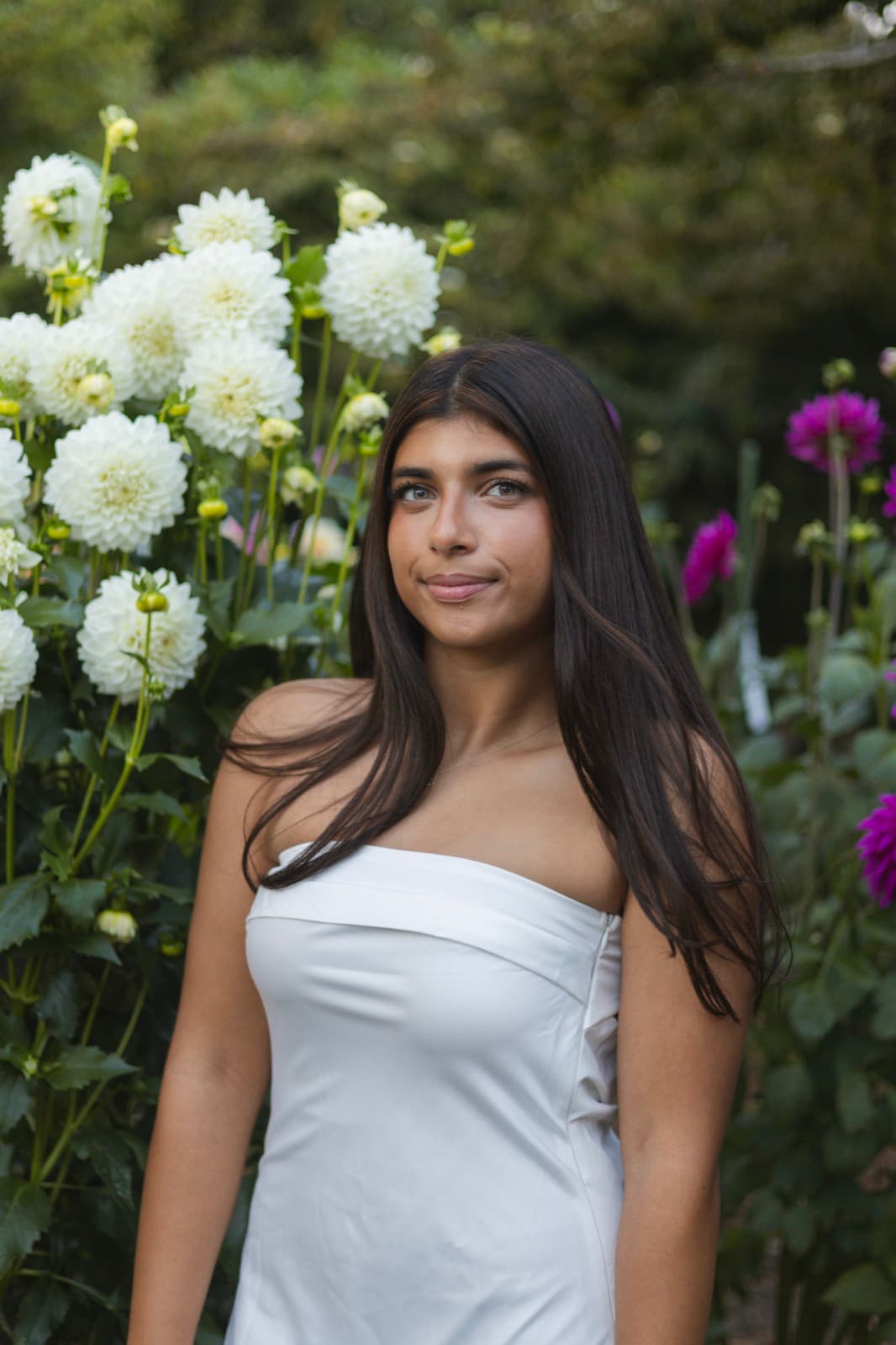 Senior portrait session beside white dahlias